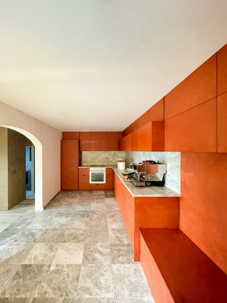 Spacious and vibrant orange MDF kitchen in the apartment.