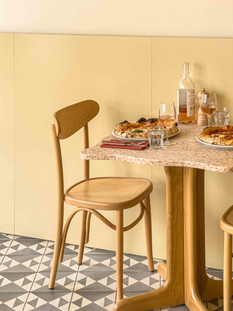 Stylish chair and table in HOXAR STUDIO's pizzeria restaurant design.