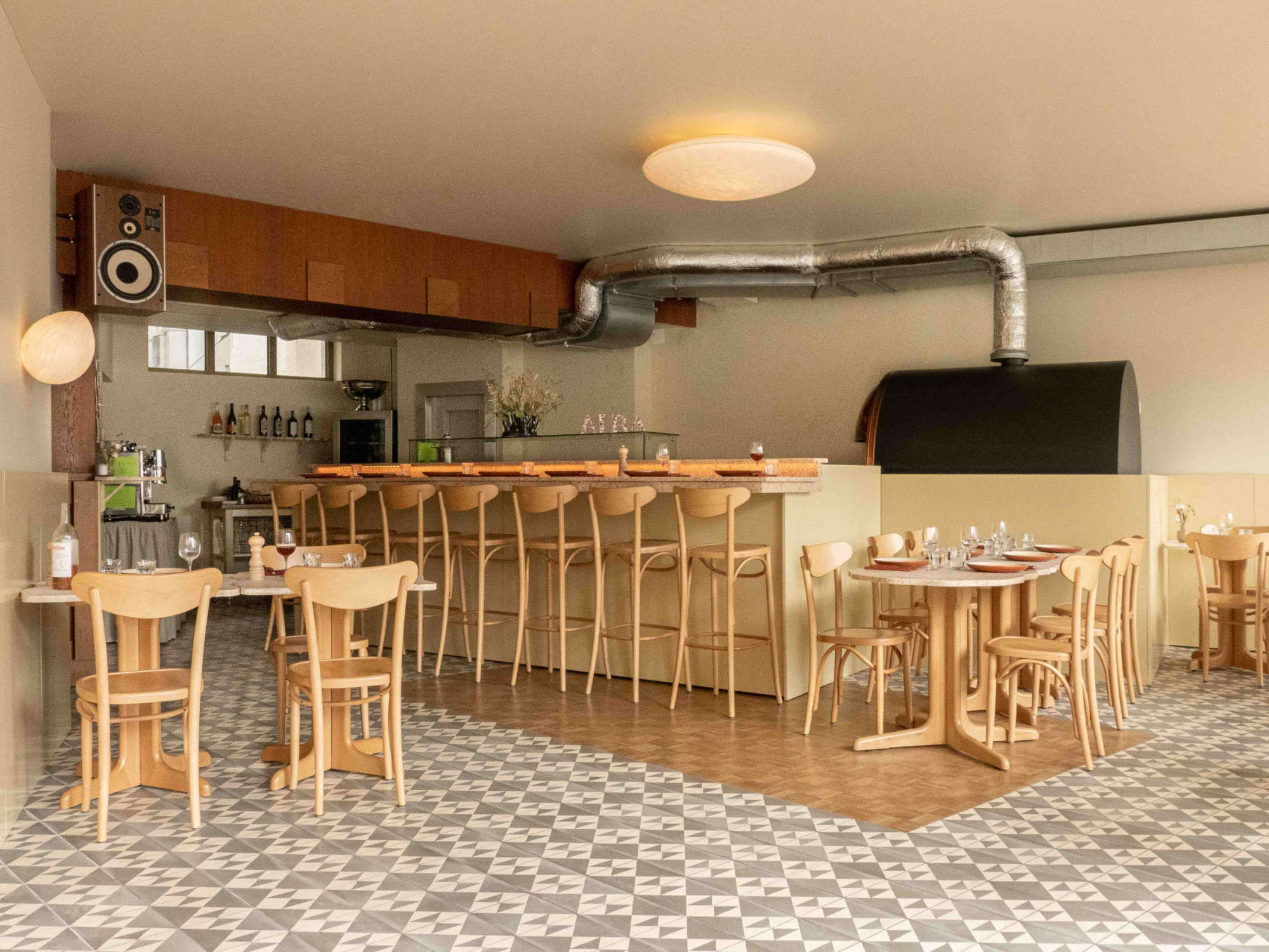 Sleek counter design in the pizzeria restaurant by HOXAR STUDIO.