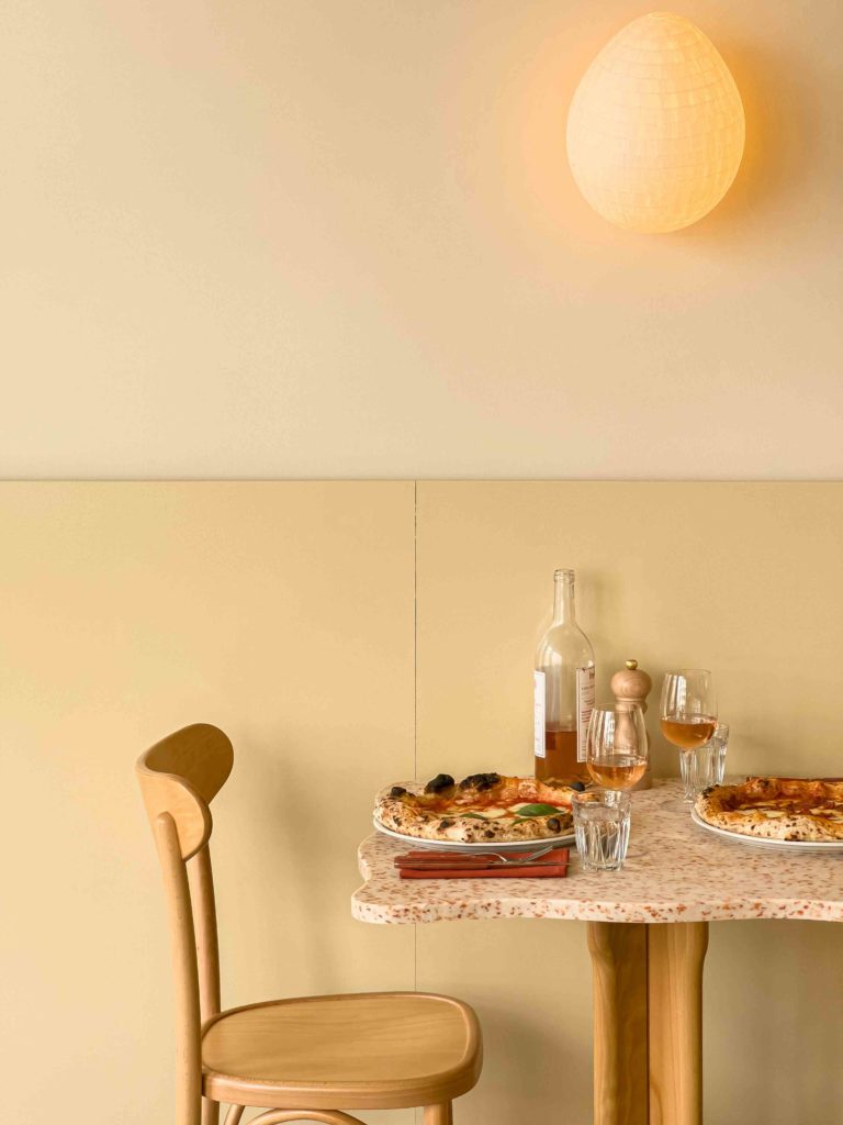 Mellow lighting in the pizzeria restaurant design by HOXAR STUDIO.