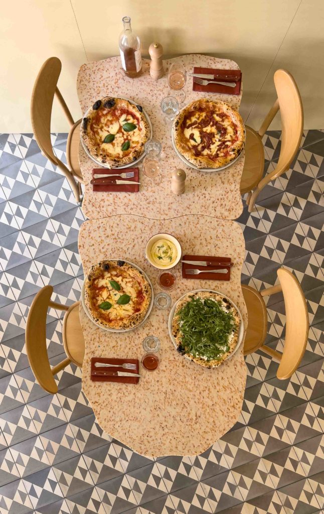 Innovative table layout in HOXAR STUDIO's pizzeria restaurant design.